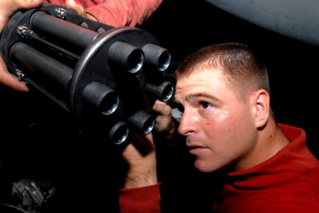 US Navy 080919-N-3610L-169 Aviation Ordinanceman 2nd Class Tyler Watts examines the barrel of a gun turret removed from an F-A-18E Hornet assigned to the
