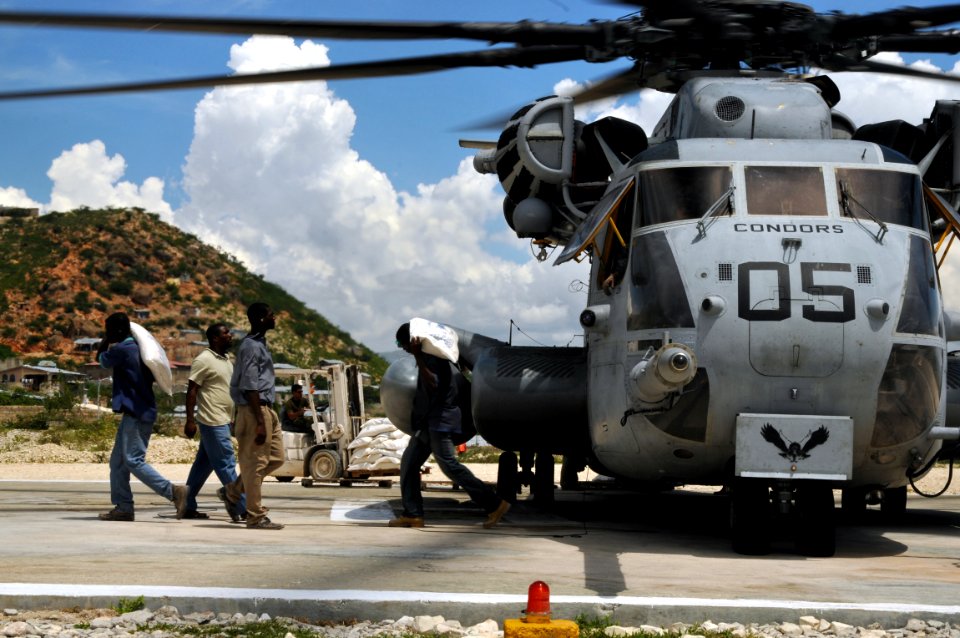 US Navy 080917-N-8907D-408 Locals and personnel embarked aboard the amphibious assault ship USS Kearsarge (LHD 3) off load food supplies during disaster relief support