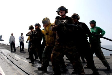 US Navy 080919-N-4995K-167 Aviation Boatswain's Mate (Handling) Alexis Fernandez yells commands to the hose team during flight deck drills aboard the Nimitz-class aircraft carrier USS Ronald Reagan (CVN 76)