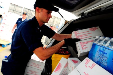US Navy 080919-N-5758H-334 Fire Controlman 2nd Class Jason Mosher, assigned to the amphibious assault ship USS Nassau (LHA 4), loads food and water into the truck of a Galveston, Texas