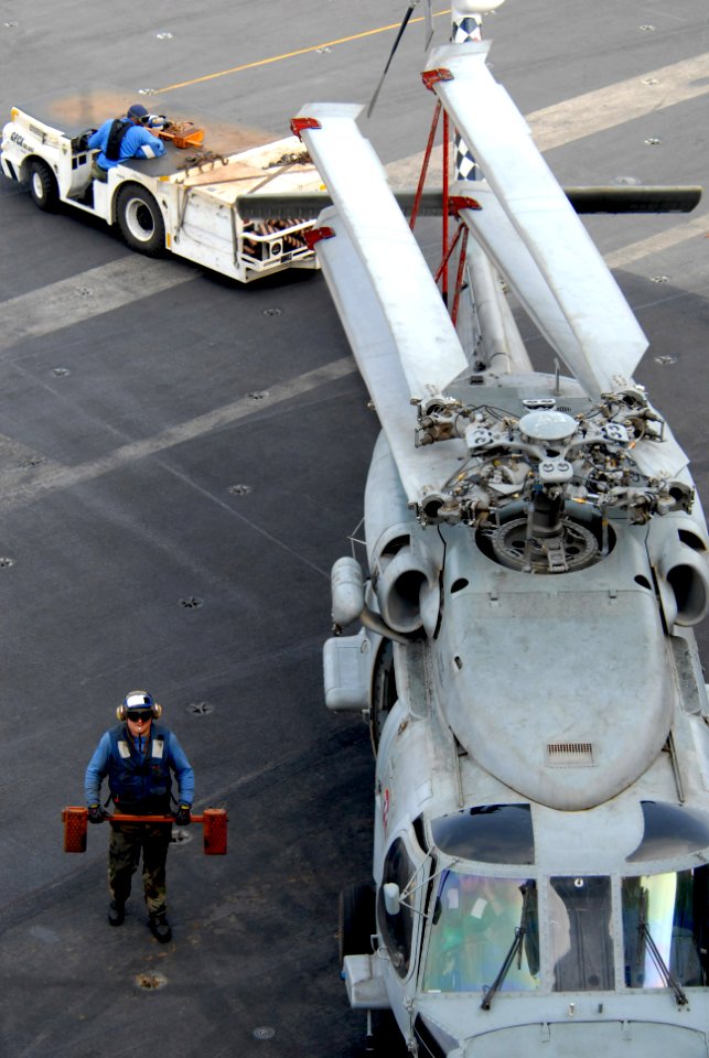 US Navy 080918-N-1635S-002 Aviation Boatswain's Mate (Handling) 2nd Class Herbert Smith uses a tractor to transfer an SH-60F Sea Hawk