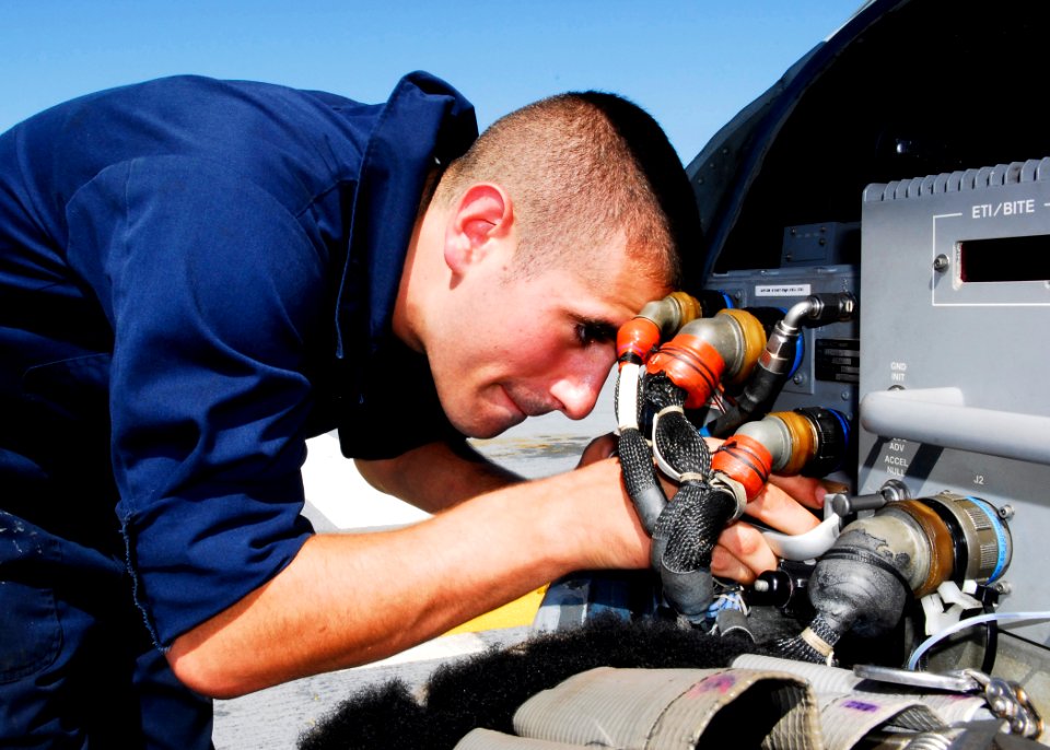 US Navy 080919-N-9520G-012 Aviation Electronic Technician Airman Sean Bamber from Cleveland, Ohio, replaces EGI batteries on the MH-60S Sea Hawk aboard the amphibious assault ship USS Essex (LHD 2)