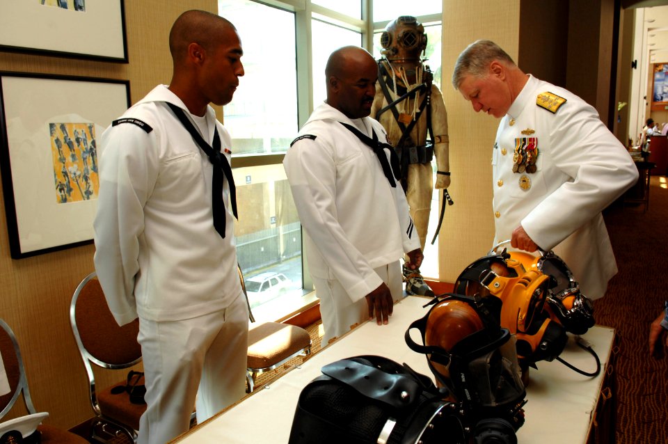 US Navy 080918-N-8273J-225 Chief of Naval Operations (CNO) Adm. Gary Roughead speaks with Navy Diver 1st Class Michael Celestine about the helmets Navy divers use while conducting maintenance on ships