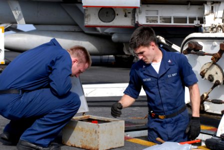 US Navy 080919-N-1635S-001 Electronics Technician 2nd Class Robert Brimberry, left, and Electronics Technician 3rd Class Daniel Hartman perform maintenance on an alignment outlet box
