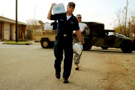 US Navy 080921-N-5758H-148 Engineman 1st Class Robert Chapman, assigned to the amphibious assault ship USS Nassau (LHA 4), carries water and ice to pass out to Galveston residents