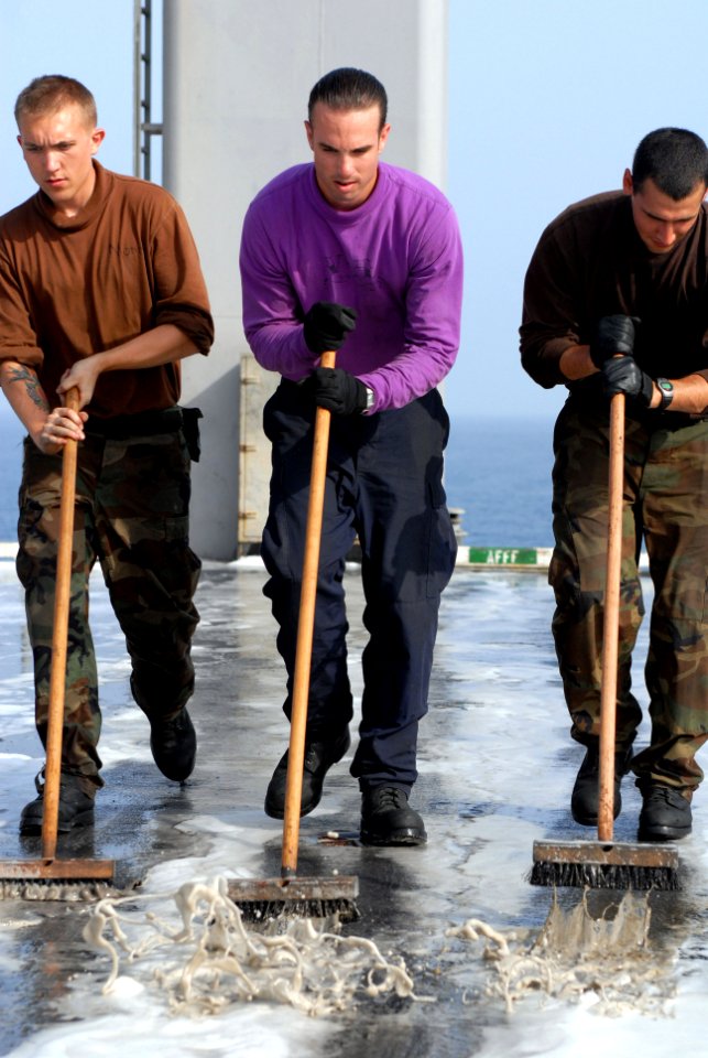 US Navy 080919-N-1635S-008 Aviation Structural Mechanic (Equipment) Airman Kevin Morris, left, Aviation Boatswain's Mate (Fuels) Airman Nicholas Gilbert and Aviation Structural Mechanic Airman Robert Reynolds use deck brushes