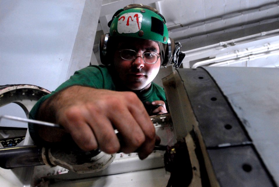 US Navy 080919-N-3610L-037 Aviation Structural Mechanic 3rd Class Anthony Herrick removes sealant before a spindle retorque on a F-A-18E Hornet assigned to the