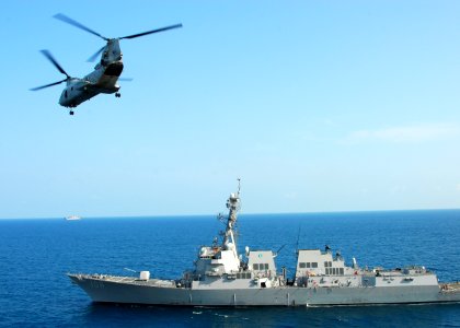 US Navy 110217-N-8607R-204 A CH-46E Sea Knight helicopter flies by the guided-missile destroyer USS Stockdale (DDG 106)