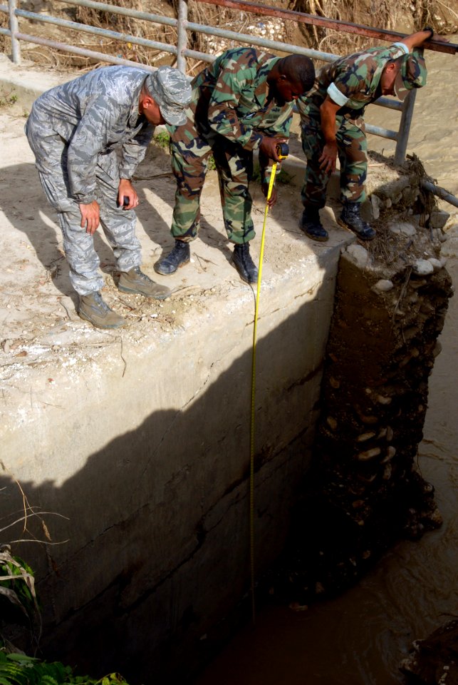 US Navy 080918-N-3595W-385 Air Force engineers and Navy Seabees embarked aboard the amphibious assault ship USS Kearsarge (LHD 3) inspect a bridge in a small community between Cabaret and Cazales that was damaged by Hurricane I