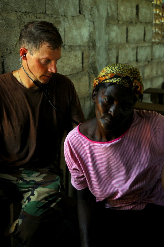 US Navy 080920-N-4515N-265 Capt. Tim Shope, a medical augmentee embarked aboard the amphibious assault ship USS Kearsarge (LHD 3), listens to the lungs and heartbeat of an elderly Haitian women photo