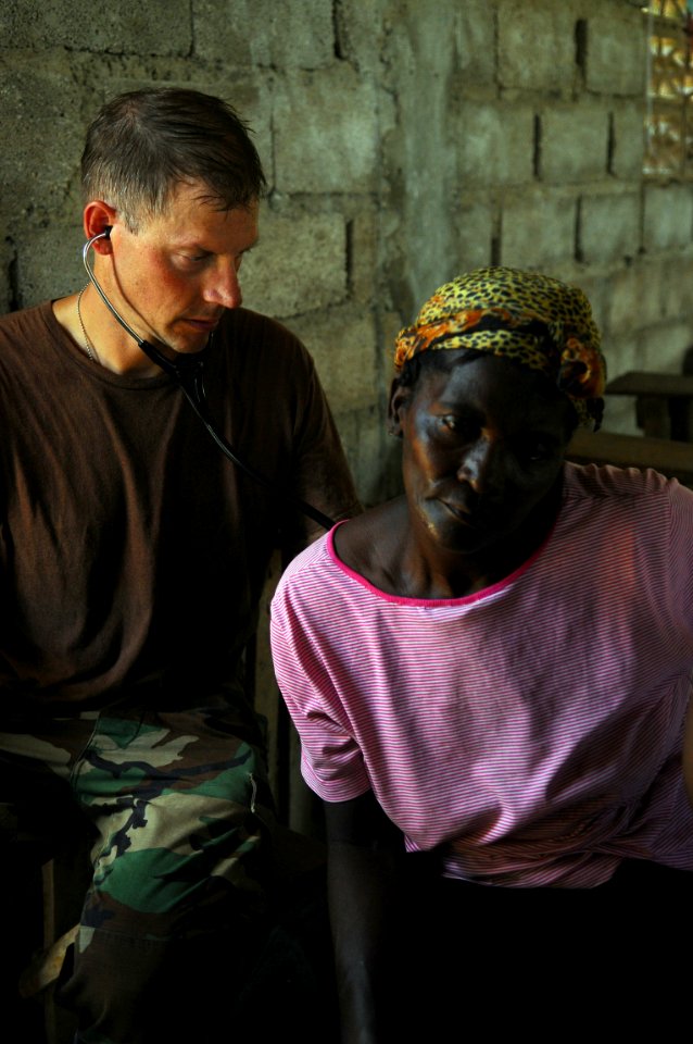 US Navy 080920-N-4515N-265 Capt. Tim Shope, a medical augmentee embarked aboard the amphibious assault ship USS Kearsarge (LHD 3), listens to the lungs and heartbeat of an elderly Haitian women