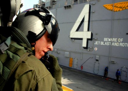US Navy 080923-N-0193M-241 Aviation Warfare Systems Operator 3rd Class Andrew Byers speaks with the pilot of the MH-60S Sea Hawk helicopter