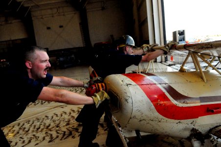 US Navy 080921-N-5758H-646 Sailors push an airplane damaged by Hurricane Ike from the Lone Star Flight Museum in Galveston