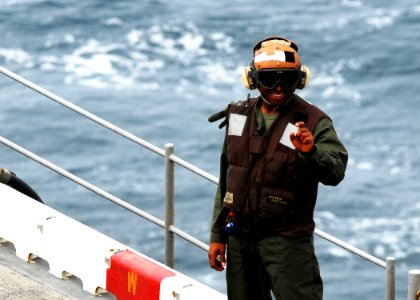 US Navy 080922-N-2183K-100 A flight deck crewman uses hand signals to communicate with other personnel on the flight