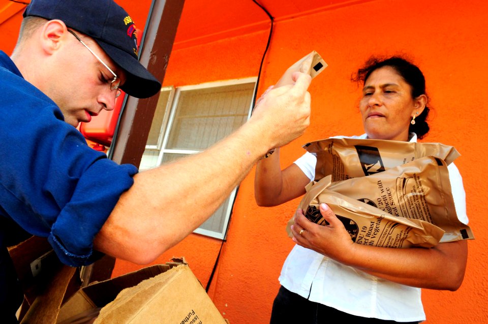 US Navy 080921-N-5758H-243 Engineman 1st Class Robert Chapman, assigned to the amphibious assault ship USS Nassau (LHA 4), gives meals ready-to-eat to a Galveston resident