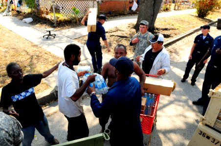 US Navy 080921-N-5758H-273 Residents of Galveston receive bleach, cots, food, ice and water from Sailors assigned to the amphibious assault ship USS Nassau (LHA 4) and members of the Army National Guard during a food convoy to