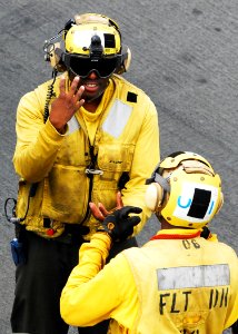 US Navy 080922-N-2183K-090 A flight deck crewman uses hand signals to communicate with other personnel