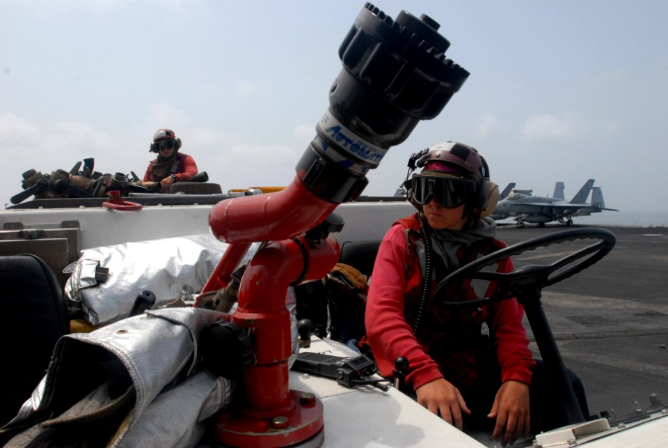 US Navy 080919-N-3610L-236 Aviation Boatswain's Mate (Handling) 2nd Class Christina Alesin stands a Crash-team fire watch over the flight deck of the Nimitz-class aircraft carrier USS Ronald Reagan (CVN 76)