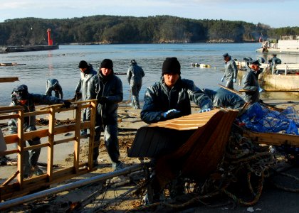 US Navy 110403-N-8607R-154 Sailors clean up debris from a harbor in Oshima, Japan