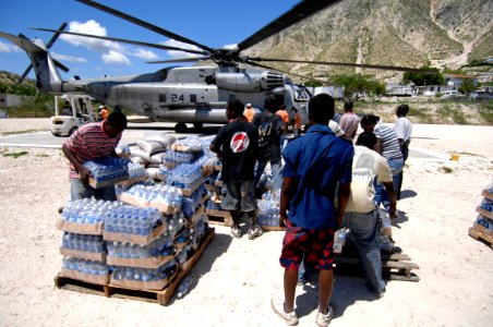 US Navy 080922-N-9620B-004 Haitian relief workers help United Nations and U.S. military service members embarked aboard the amphibious assault ship USS Kearsarge (LHD 3) unload food and water to aid those affected by the recent photo