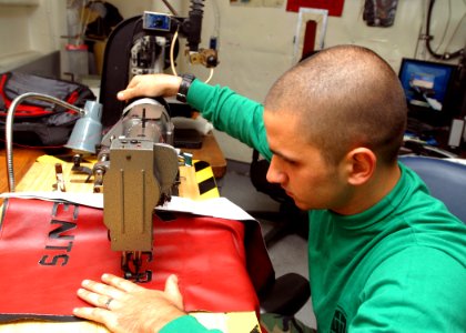 US Navy 080923-N-2456S-056 Aircrew Survival Equipmentman 2nd Class Trevor Lafferty sews a seat cover for the Air Ops Officer