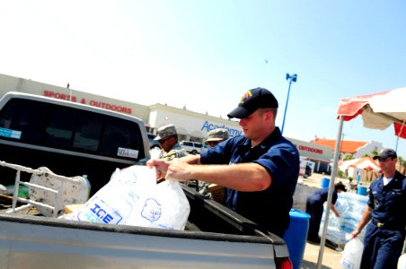 US Navy 080920-N-5758H-228 Fire Controlman 2nd Class Joseph Phillips, assigned to the amphibious assault ship USS Nassau (LHA 4), puts ice in the truck of a Galveston, Texas, resident at a supply distribution point