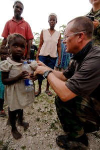 US Navy 080924-N-9620B-012 Cmdr. John King, assigned to the amphibious assault ship USS Kearsarge (LHD 3), assesses the health of a Haitian girl during a medical assessment conducted to determine future medical aid photo
