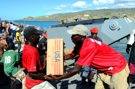 US Navy 080922-N-7955L-118 Haitian civilians help move boxes of cooking oil delivered by U.S. service members embarked aboard the amphibious assault ship USS Kearsarge (LHD 3) during a humanitarian assistance mission photo