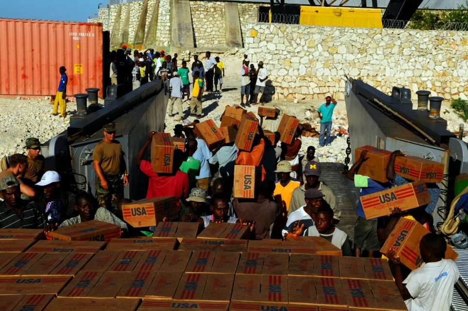 US Navy 080926-N-4515N-011 Haitian civilians unload relief supplies from a landing craft utility assigned to Assault Craft Unit (ACU) 2 embarked aboard the amphibious assault ship USS Kearsarge (LHD 3)