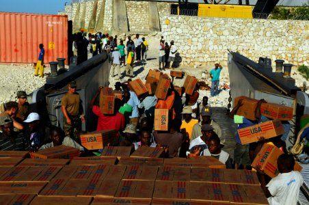 US Navy 080926-N-4515N-011 Haitian civilians unload relief supplies from a landing craft utility assigned to Assault Craft Unit (ACU) 2 embarked aboard the amphibious assault ship USS Kearsarge (LHD 3) photo
