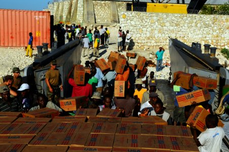 US Navy 080926-N-4515N-011 Haitian civilians unload relief supplies from a landing craft utility assigned to Assault Craft Unit (ACU) 2 embarked aboard the amphibious assault ship USS Kearsarge (LHD 3)