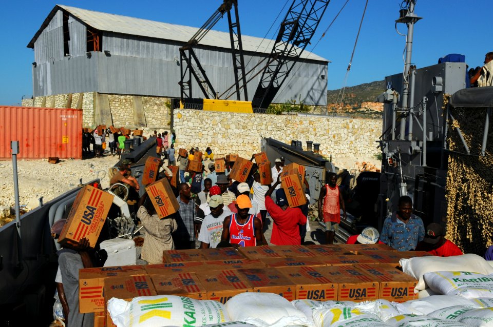 US Navy 080926-N-4515N-105 Haitian civilians unload relief supplies from a landing craft utility assigned to Assault Craft Unit (ACU) 2 embarked aboard the amphibious assault ship USS Kearsarge (LHD 3)