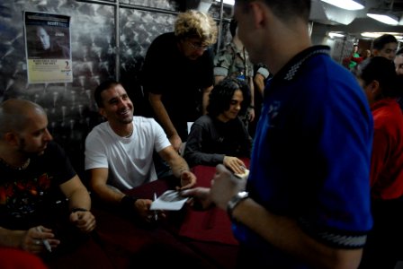 US Navy 080924-N-4005H-161 Scott Stapp , hands back a signed CD to Aviation Boatswain's Mate (Equipment) Airman Troy Cloe photo