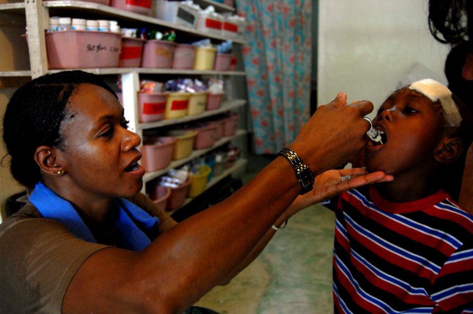 US Navy 080923-N-7544A-274 Lt. Pandora Liptrot, a Navy Nurse Corps officer embarked aboard the amphibious assault ship USS Kearsarge (LHD 3) gives deworming medication to a child at the Center of the Grace of Good Samaritan Orp