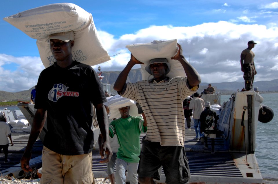 US Navy 080923-N-9620B-001 Haitian relief workers assist service members embarked aboard the amphibious assault ship USS Kearsarge (LHD 3) unload food and water to aid those affected by recent hurricanes that have struck Haiti