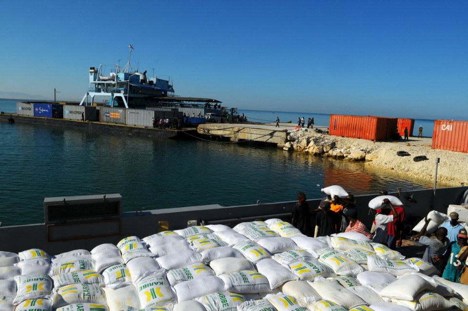 US Navy 080926-N-4515N-137 Haitian civilians unload relief supplies from a landing craft utility assigned to Assault Craft Unit (ACU) 2 embarked aboard the amphibious assault ship USS Kearsarge (LHD 3)