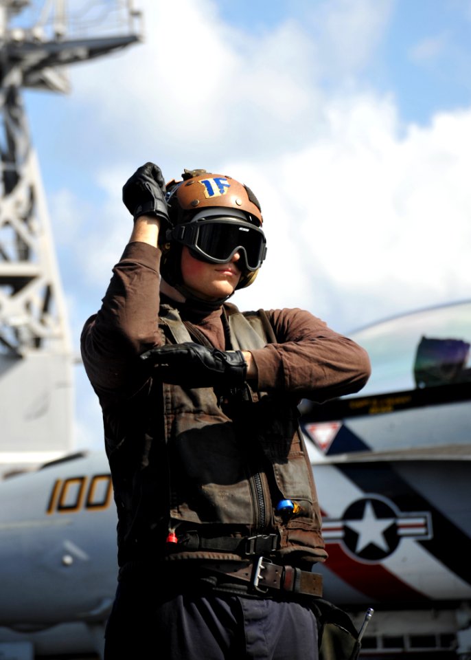 US Navy 110131-N-4973M-059 Aviation Electrician's Mate Airman Joel Blodgett relays pre-flight check signals