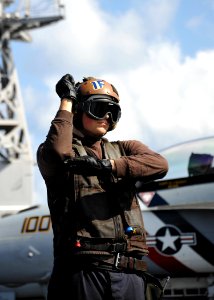 US Navy 110131-N-4973M-059 Aviation Electrician's Mate Airman Joel Blodgett relays pre-flight check signals