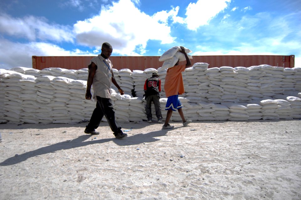 US Navy 080923-N-9620B-009 Haitian relief workers assist service members embarked aboard the amphibious assault ship USS Kearsarge (LHD 3) unload food and water to aid those affected by recent hurricanes that have struck Haiti