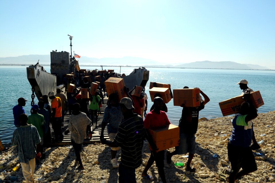 US Navy 080926-N-4515N-054 Haitian civilians unload relief supplies from a landing craft utility assigned to Assault Craft Unit (ACU) 2 embarked aboard the amphibious assault ship USS Kearsarge (LHD 3)