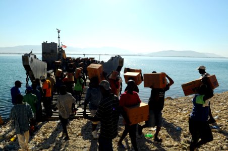 US Navy 080926-N-4515N-054 Haitian civilians unload relief supplies from a landing craft utility assigned to Assault Craft Unit (ACU) 2 embarked aboard the amphibious assault ship USS Kearsarge (LHD 3) photo