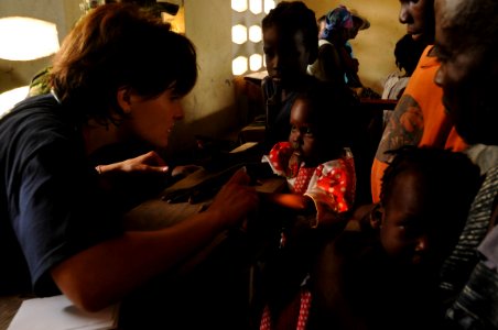 US Navy 080924-N-8907D-098 Hilary Warren examines a child during medical aid operations at a neighborhood school photo
