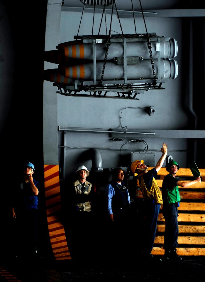 US Navy 080926-N-9928E-126 Sailors lower ordnance in the hangar bay aboard the Nimitz-class aircraft carrier USS John C. Stennis (CVN 74)