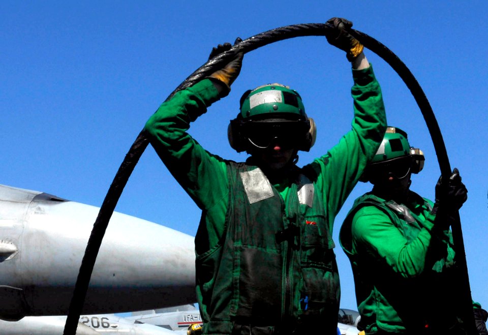 US Navy 080930-N-9928E-008 Aviation Boatswain's Mate (Equipment) 3rd Class Zachary Bray and Aviation Boatswain's Mate (Equipment) 3rd Class Demond Warrior wrap a new arresting gear cable
