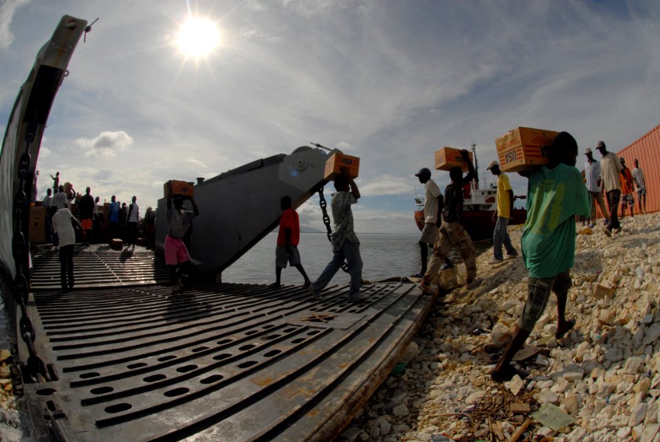 US Navy 080924-N-3595W-158 Haitians help Sailors offload disaster relief supplies from a landing craft, utility