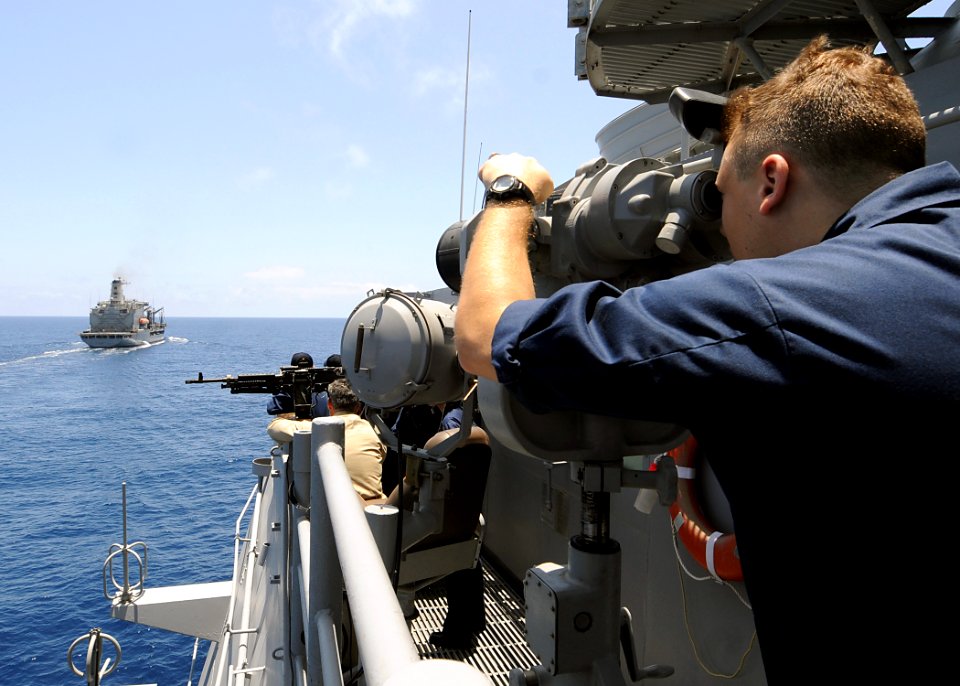 US Navy 080928-N-1082Z-031 Quarter Master 3rd Class David Kaelin observes the Military Sealift Command fleet replenishment oiler USNS John Lenthall (T-AO 189) through the
