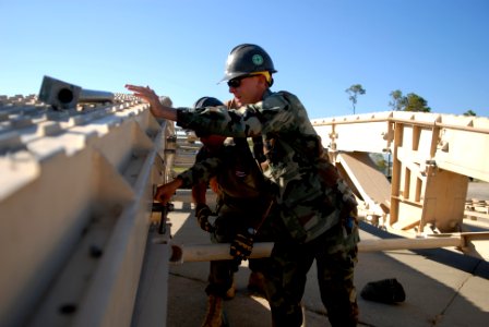 US Navy 081001-N-3674H-179 Utilitiesman 3rd Class Daryl Reineke attaches a section of a medium girder bridge