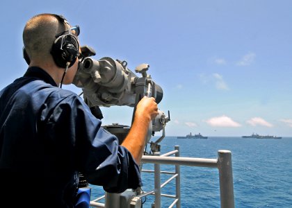 US Navy 081002-N-1082Z-027 A Sailor aboard an unidentified U.S. Navy ship observes a vertical replenishment between the Military Sealift Command combat stores ship USNS San Jose (T-AFS 7), the multi-purpose amphibious assault s