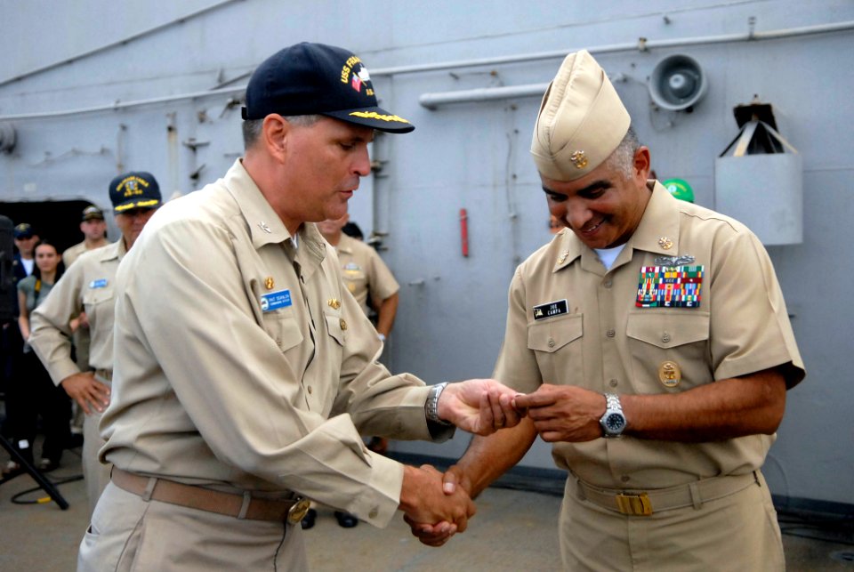 US Navy 081003-N-9818V-198 Capt. Patrick Scanlon, commanding officer of the submarine tender USS Frank Cable (AS 40), presents Master Chief Petty Officer of the Navy (MCPON) Joe R. Campa Jr. with a ship's coin during an all-han
