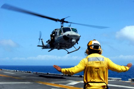 US Navy 081001-N-4856C-034 Aviation Boatswain's Mate (Handling) 3rd Class Demetrius Davis signals to a UH-1